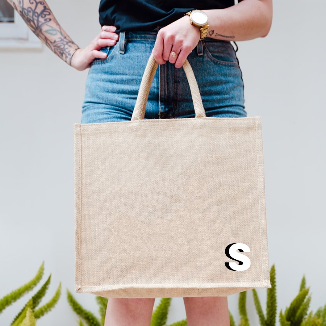 A jute tote with a "J" monogrammed on the bottom corner
